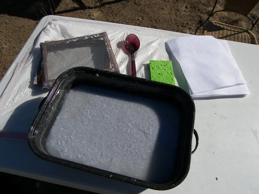 Paper mould and a tray of wet pulp laid out for hand papermaking
